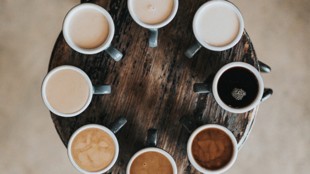Top down view of 8 different types of coffee cups lined up in a circle.