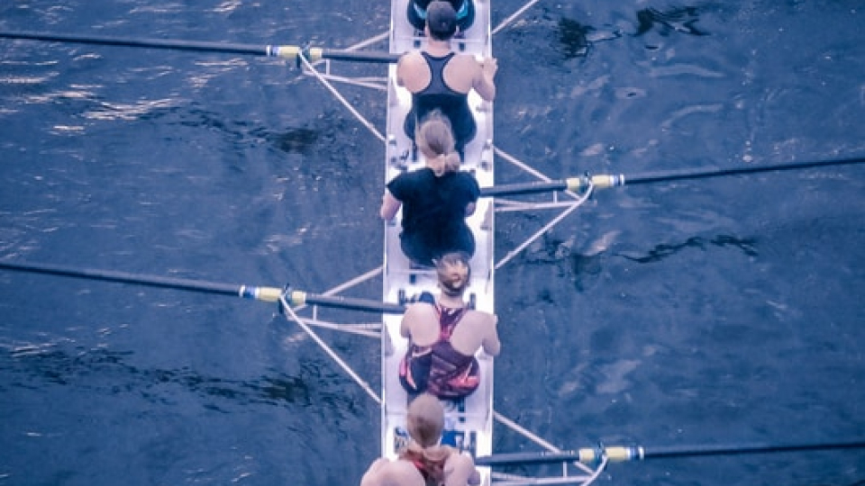 Top down view of a team working together to row a boat.
