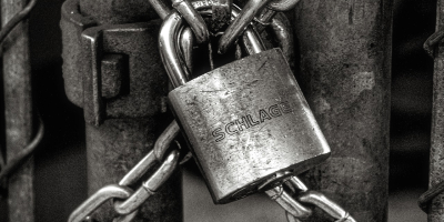 Black and white image of padlock and chains.